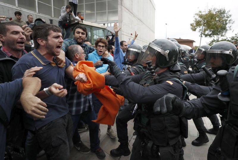 A lépcsőről ugrott a tiltakozóra a rohamrendőr – videókon a katalán népszavazás