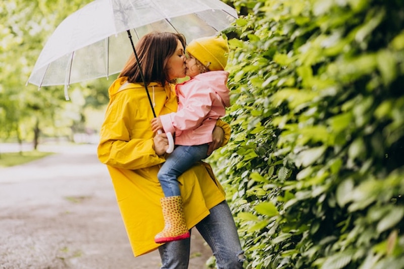 mother-with-daughter-walking-rain-umbrella_1303-22761